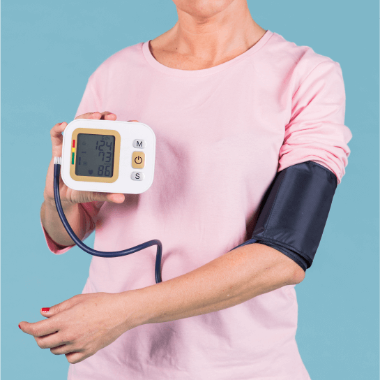 Woman demonstrating a blood pressure checkup in Bhopal using an automatic electronic monitor with cuff on upper arm.