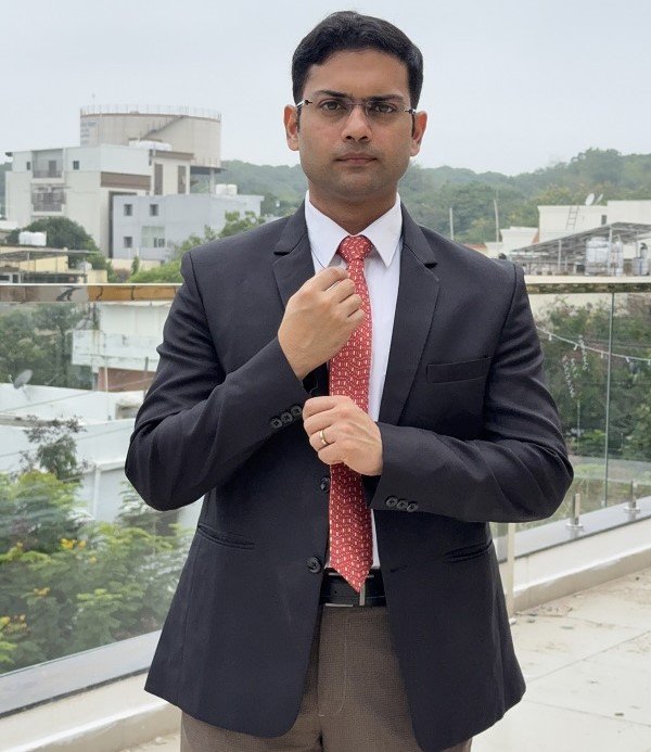 Dr. Swapnil S Garde, acclaimed as one of the best cardiologist doctors in Bhopal, poses confidently in a suit on a hospital rooftop.