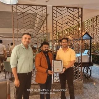 Award ceremony where Dr. Swapnil Garde is honored with a certificate, flanked by respected peers, demonstrating achievements as best cardiologist in Bhopal.